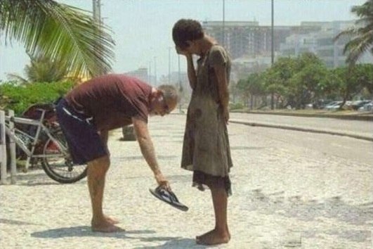 Это фотография человека, дающего свою обувь бездомной дев