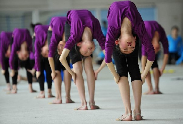 Студентки растягиваются на тренировке в гимнастической ш
