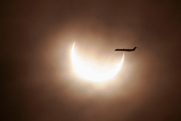 Самолет пролетает мимо солнечного диска во время затмения