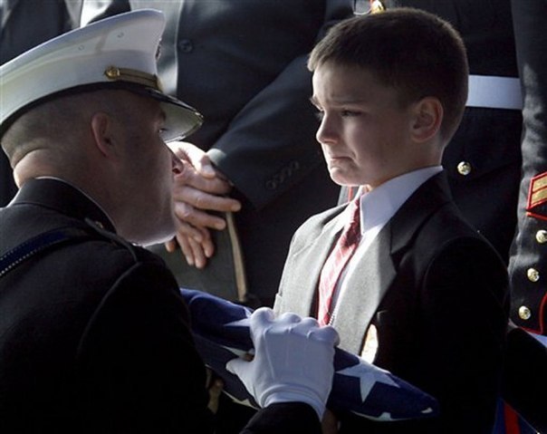 Восьмилетний Кристиан принимает флаг во время поминально